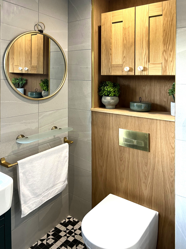 Small contemporary 3/4 bathroom in London with furniture-like cabinets, green cabinets, a drop-in tub, a shower/bathtub combo, a wall-mount toilet, marble, white walls, ceramic floors, a console sink, black floor, a shower curtain, white benchtops, a single vanity and a built-in vanity.