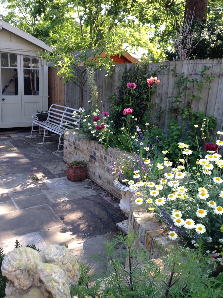 This is an example of a shabby-chic style garden in Surrey.