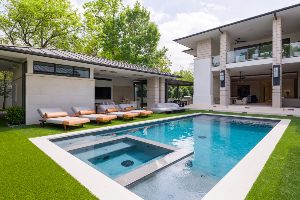 Expansive midcentury backyard rectangular pool in Dallas with a pool house and natural stone pavers.