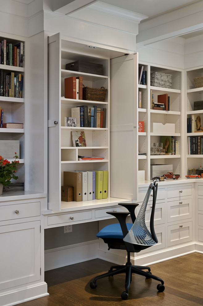 Traditional home office in New York with a built-in desk and white walls.