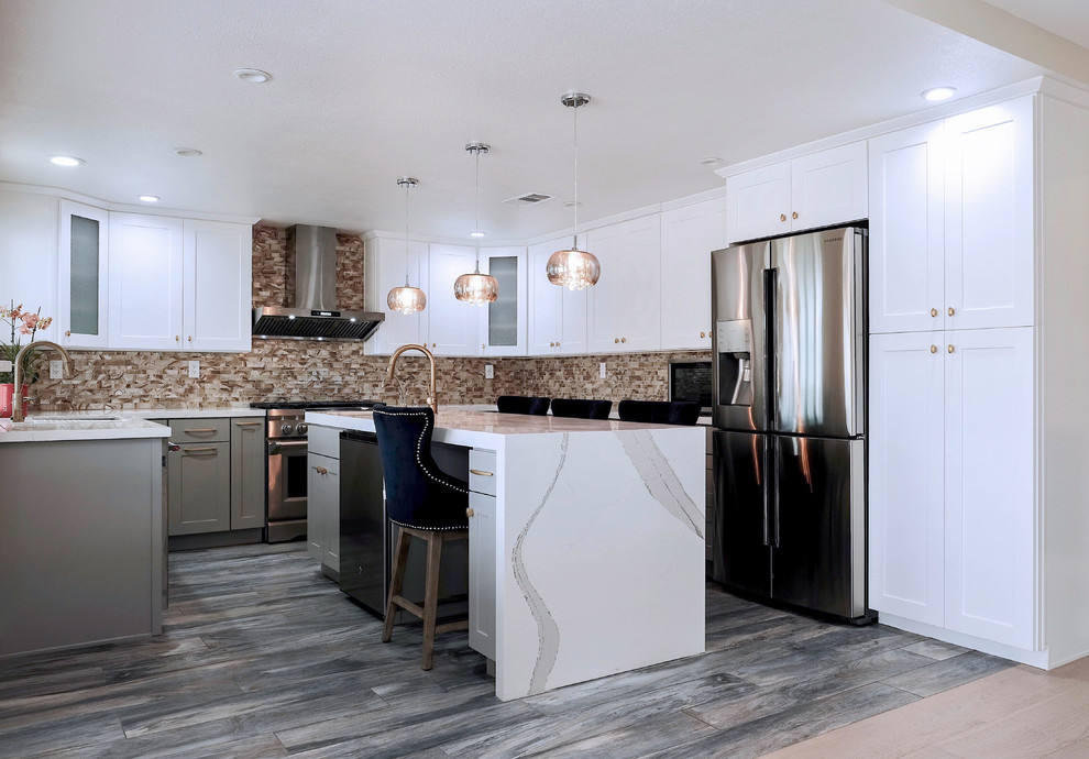 This is an example of a large asian u-shaped kitchen in Los Angeles with a drop-in sink, shaker cabinets, white cabinets, laminate benchtops, multi-coloured splashback, glass sheet splashback, stainless steel appliances, medium hardwood floors, with island and grey floor.