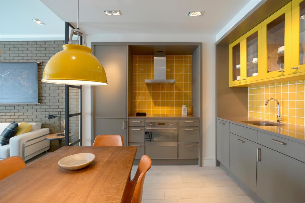 Inspiration for a mid-sized contemporary l-shaped eat-in kitchen in Barcelona with an undermount sink, flat-panel cabinets, grey cabinets, yellow splashback, ceramic splashback, stainless steel appliances, no island and beige floor.