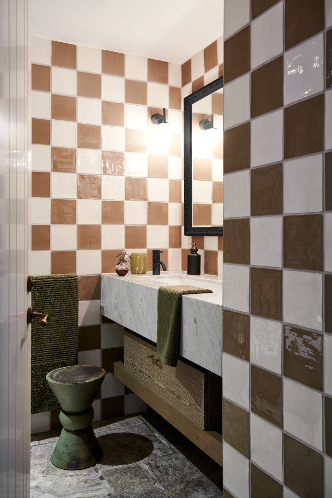 Идея дизайна: туалет среднего размера в стиле фьюжн с фасадами островного типа, светлыми деревянными фасадами, унитазом-моноблоком, белой плиткой, плиткой кабанчик, белыми стенами, полом из травертина, врезной раковиной, мраморной столешницей, серым полом, серой столешницей и подвесной тумбой