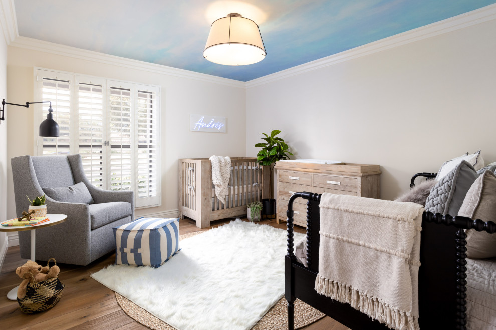 Example of a mid-sized transitional boy light wood floor and brown floor nursery design in Phoenix with blue walls