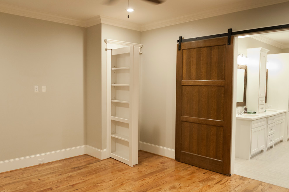 Large transitional master medium tone wood floor bedroom photo in Houston with beige walls
