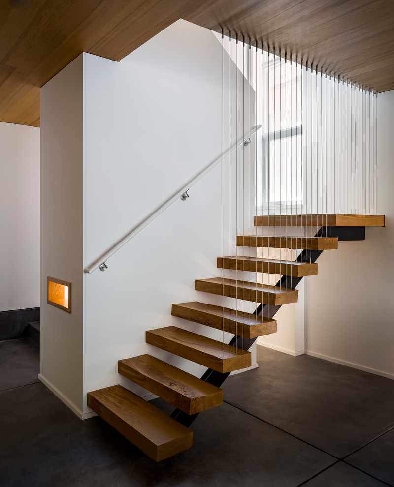 Photo of a mid-sized modern wood u-shaped staircase in San Francisco with open risers.