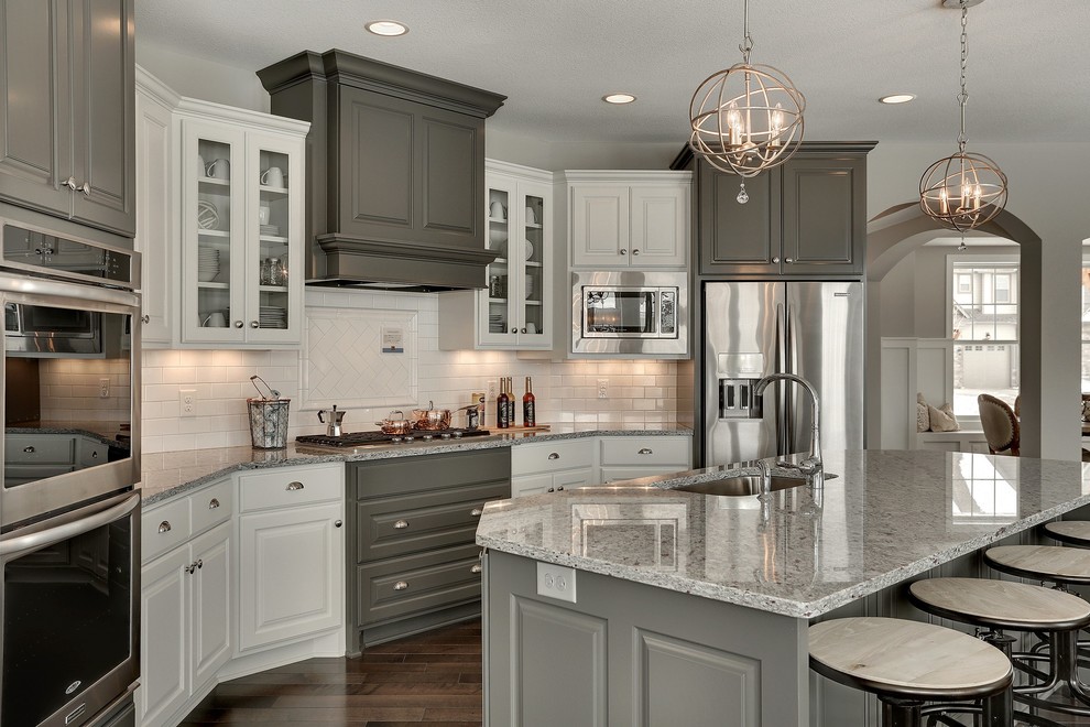 Inspiration for a large transitional u-shaped open plan kitchen in Minneapolis with an undermount sink, raised-panel cabinets, grey cabinets, granite benchtops, white splashback, subway tile splashback, stainless steel appliances and with island.