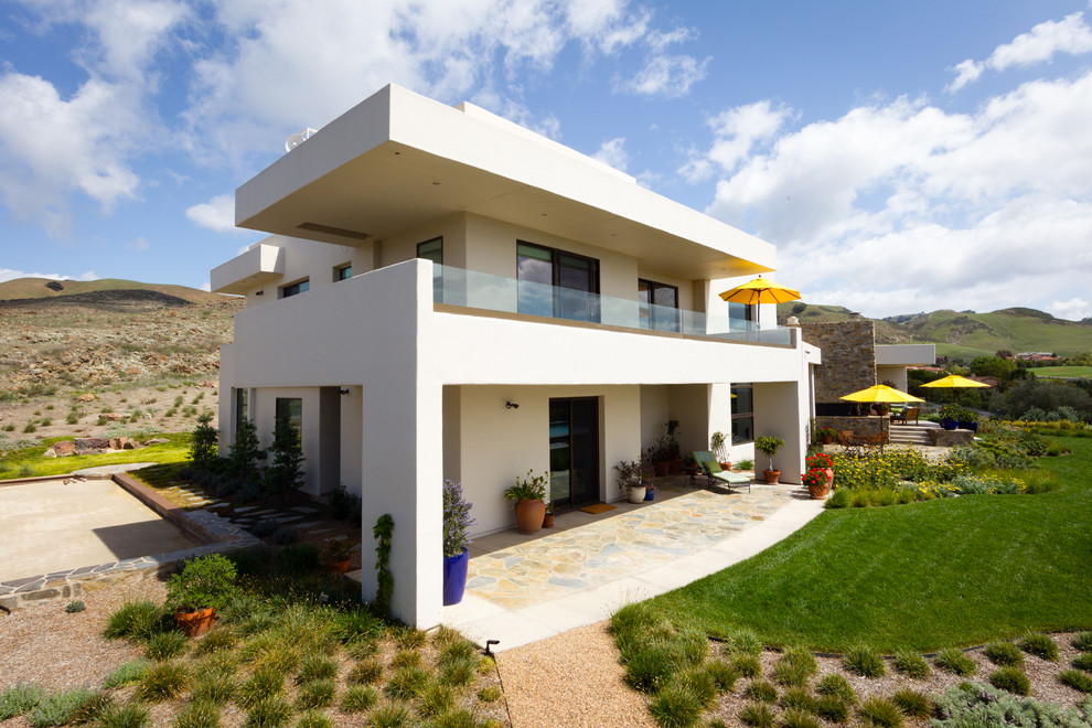 Design ideas for a large contemporary two-storey stucco beige exterior in San Luis Obispo with a flat roof.