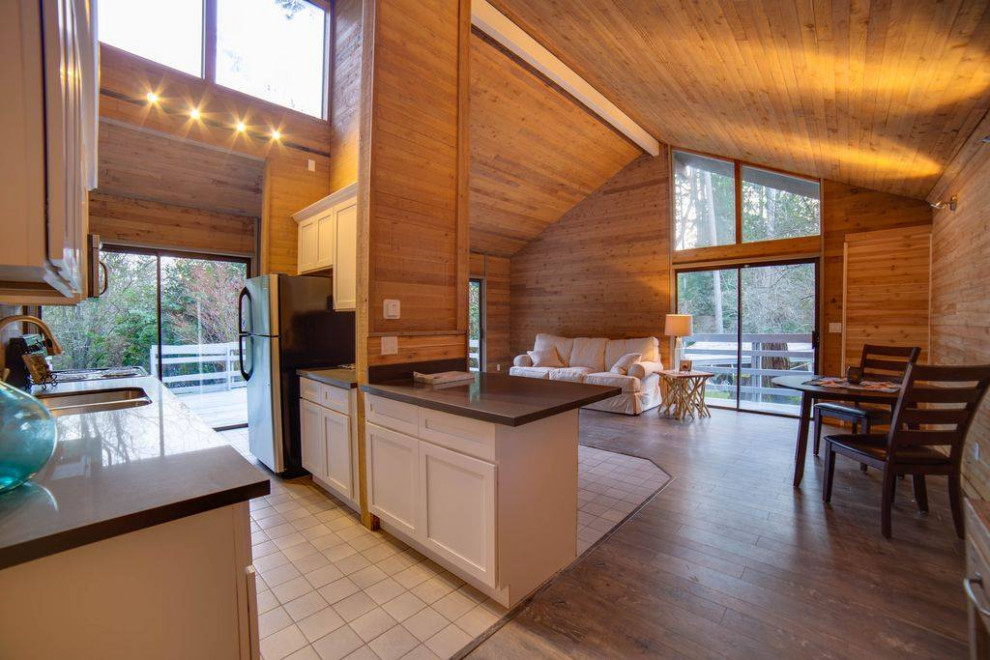 Eat-in kitchen - small galley laminate floor, gray floor and wood ceiling eat-in kitchen idea in Seattle with an integrated sink, shaker cabinets, white cabinets, quartzite countertops, white backsplash, stainless steel appliances, an island and gray countertops
