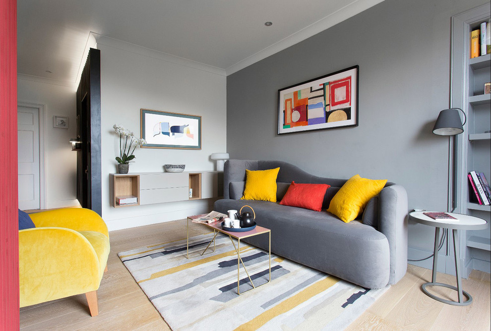 Photo of a contemporary open plan living room in Edinburgh with grey walls, light hardwood flooring, no fireplace, a wall mounted tv and beige floors.