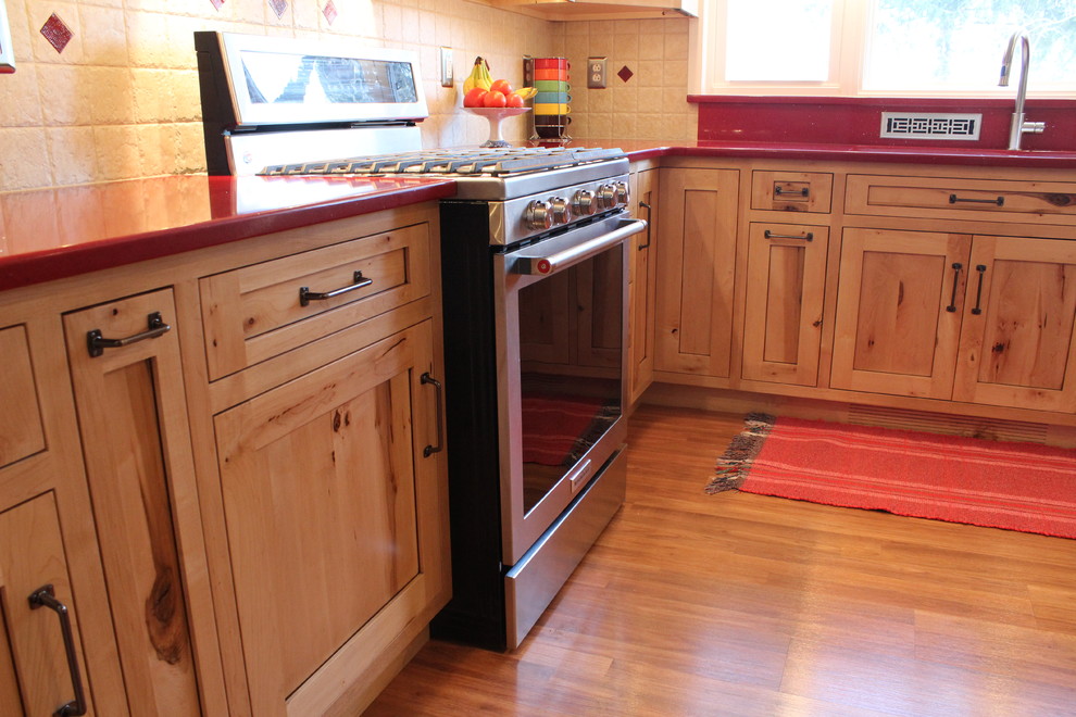 Inspiration for a mid-sized rustic l-shaped laminate floor enclosed kitchen remodel in Philadelphia with a double-bowl sink, shaker cabinets, light wood cabinets, quartz countertops, beige backsplash, ceramic backsplash, stainless steel appliances and no island