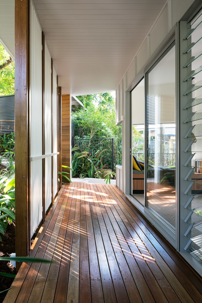 Photo of a midcentury side yard deck in Brisbane with a roof extension.