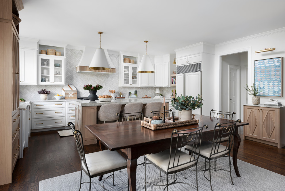 Design ideas for a mid-sized transitional u-shaped open plan kitchen in Chicago with a farmhouse sink, flat-panel cabinets, white cabinets, quartzite benchtops, white splashback, terra-cotta splashback, panelled appliances, dark hardwood floors, with island, brown floor, grey benchtop and wood.