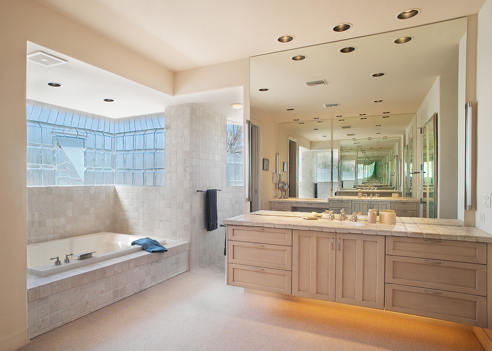Inspiration for a bathroom in Phoenix with shaker cabinets, light wood cabinets, tile benchtops, a drop-in tub, an open shower, beige tile, stone tile and an open shower.