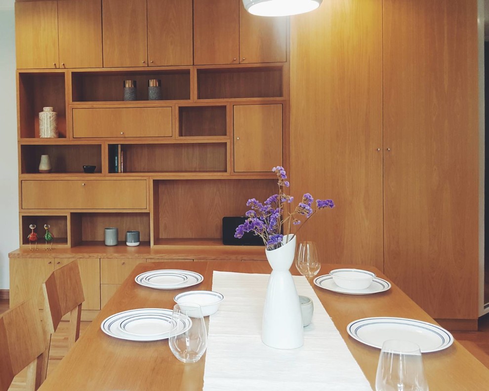 Example of a small medium tone wood floor and brown floor kitchen/dining room combo design with gray walls and no fireplace