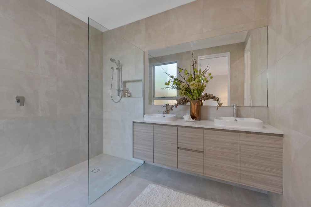 Inspiration for a mid-sized beach style master bathroom in Sunshine Coast with light wood cabinets, an open shower, a one-piece toilet, beige tile, porcelain tile, beige walls, porcelain floors, a drop-in sink, engineered quartz benchtops, beige floor, an open shower, white benchtops, a niche, a double vanity and a floating vanity.