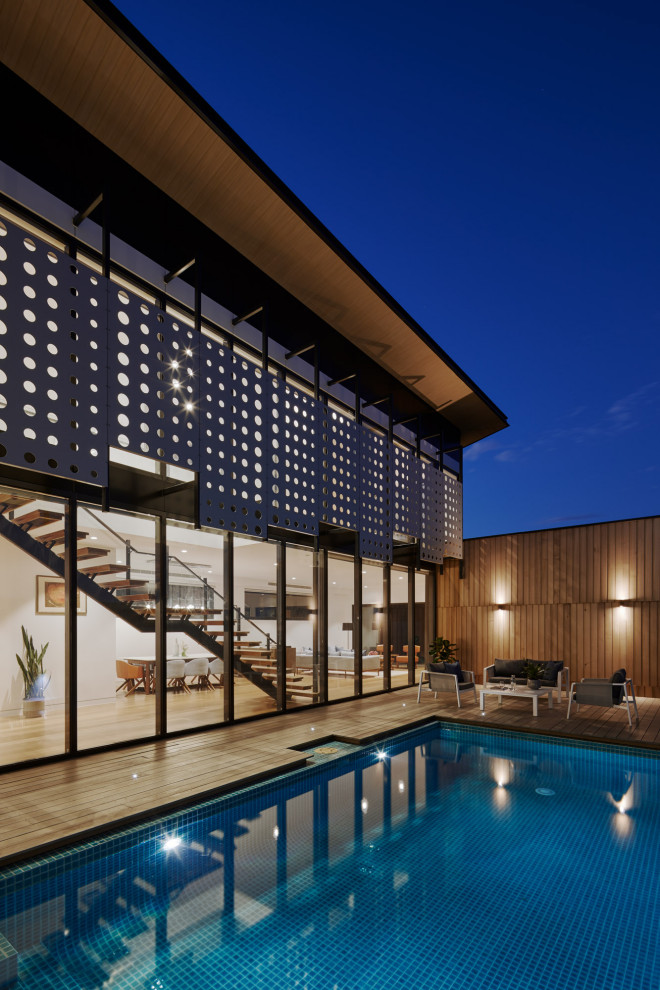 Design ideas for a large contemporary side yard rectangular aboveground pool in Melbourne with decking.
