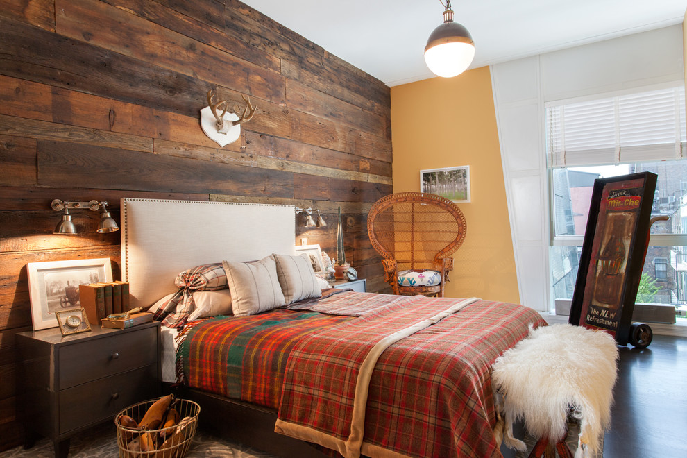 This is an example of a country guest bedroom in New York with orange walls and dark hardwood floors.
