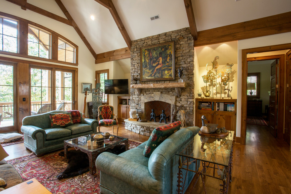 Inspiration for a large arts and crafts open concept family room in Other with beige walls, medium hardwood floors, a standard fireplace, a stone fireplace surround and a wall-mounted tv.