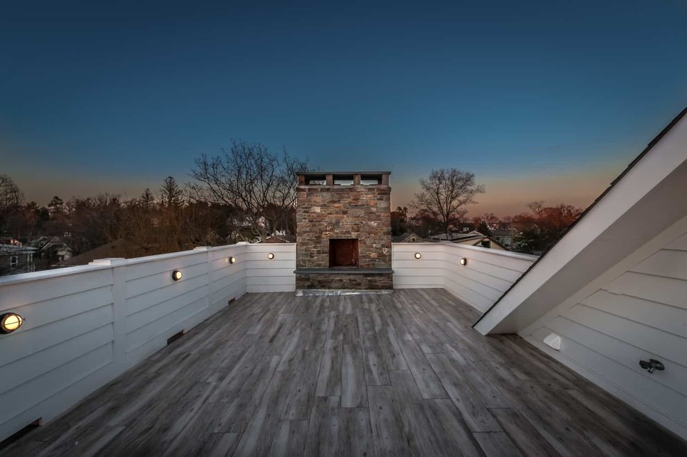 This is an example of a mid-sized beach style rooftop deck in New York with with fireplace and no cover.