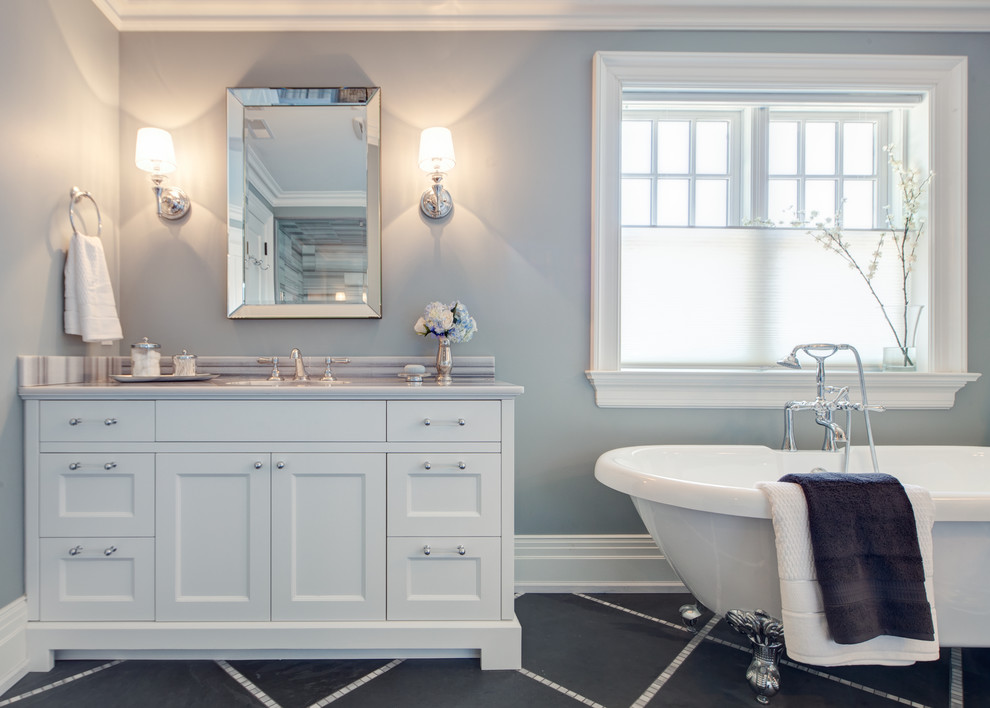 This is an example of a traditional bathroom in Toronto with an undermount sink, shaker cabinets, white cabinets, marble benchtops, a claw-foot tub, black tile and stone tile.