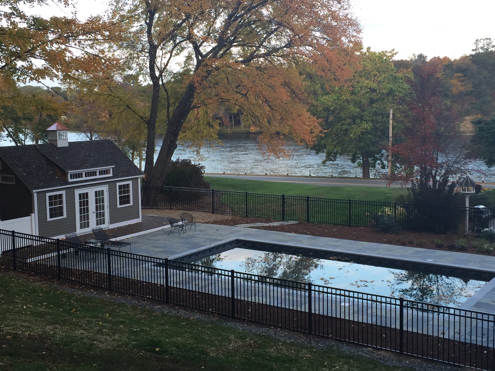 Photo of a mid-sized traditional side yard rectangular lap pool in Boston with concrete pavers.