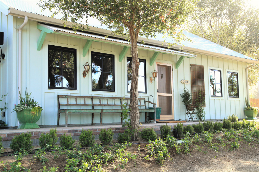 Foto della villa blu country con rivestimento in legno, copertura in metallo o lamiera, tetto grigio e pannelli e listelle di legno