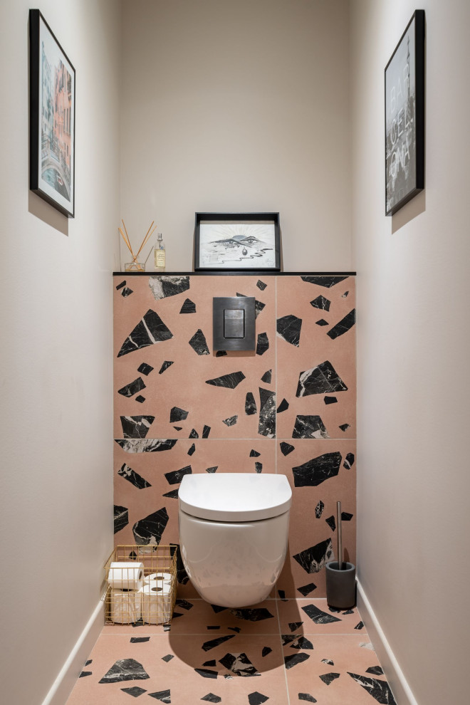 This is an example of a mid-sized contemporary powder room in Saint-Etienne with a wall-mount toilet and pink floor.