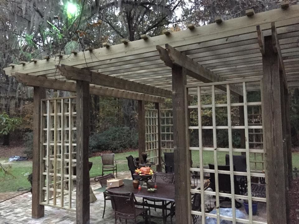 Mid-sized transitional backyard concrete patio photo in Jackson with a pergola