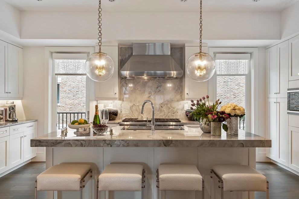Inspiration for a transitional dark wood floor kitchen remodel with shaker cabinets, white cabinets, gray backsplash, stone slab backsplash, stainless steel appliances, an island and gray countertops