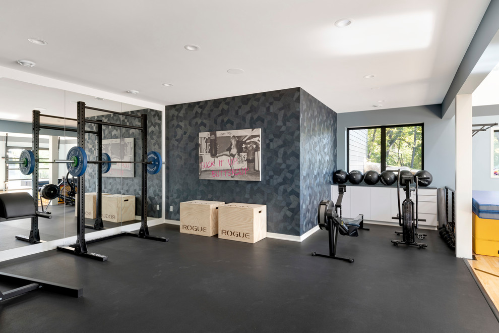 Photo of a large contemporary home weight room in Minneapolis with multi-coloured walls and black floor.
