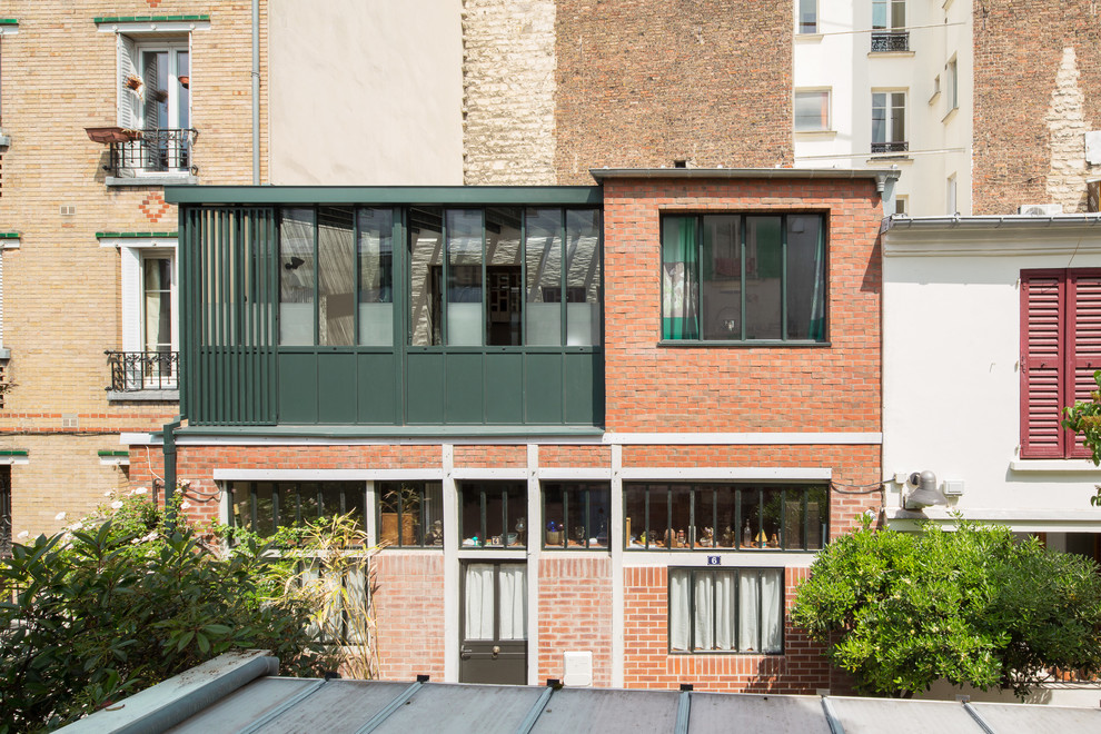 Idée de décoration pour façade de maison de ville en brique avec un toit en métal.