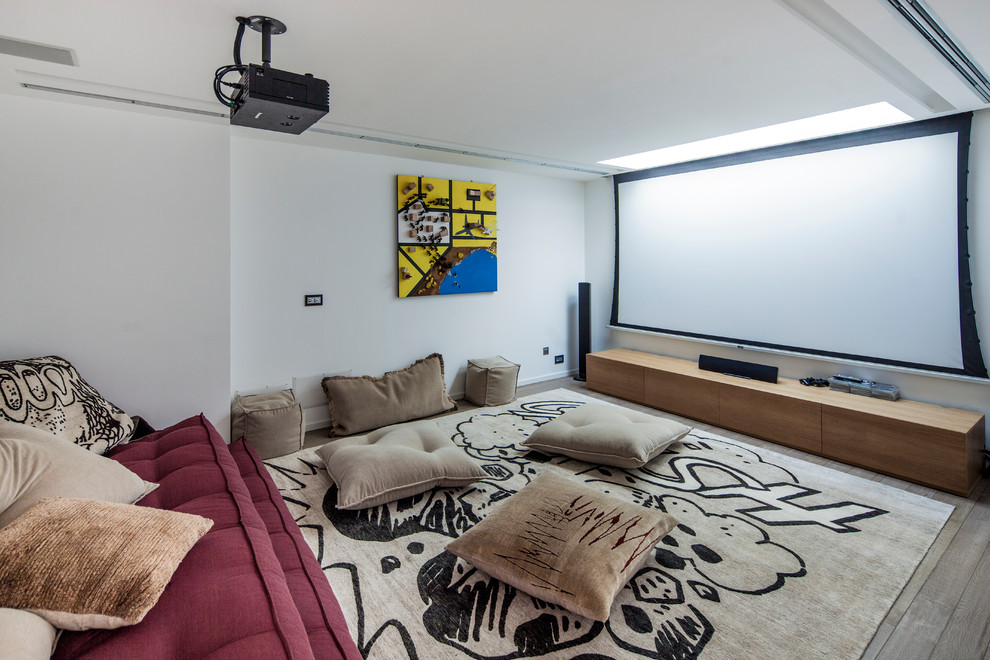 Large eclectic home theatre in Turin with white walls, light hardwood floors and a projector screen.