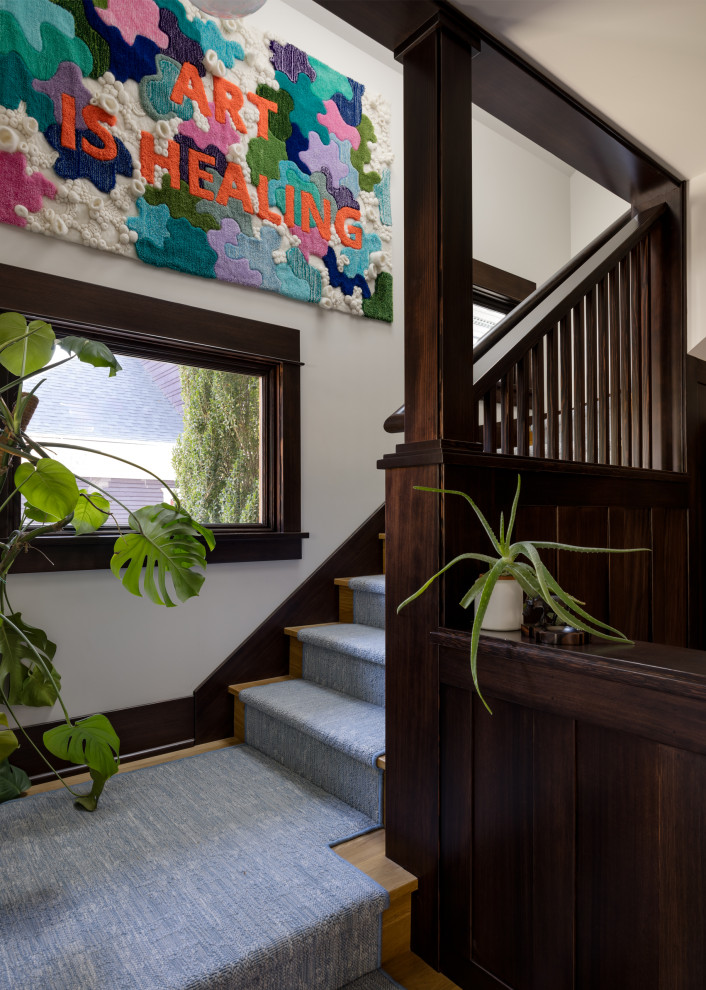 Eclectic carpeted u-shaped wood railing staircase photo in Seattle with wooden risers