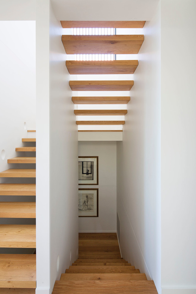Mid-sized contemporary wood u-shaped staircase in Sydney with open risers.