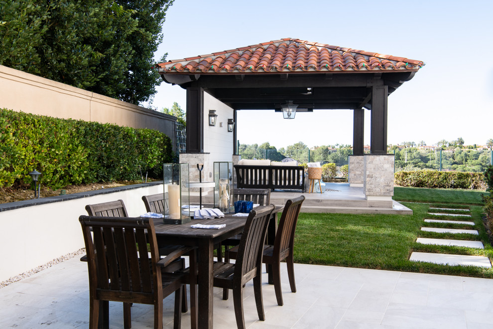 Photo of a mediterranean backyard patio in Orange County with a fire feature, concrete pavers and a gazebo/cabana.