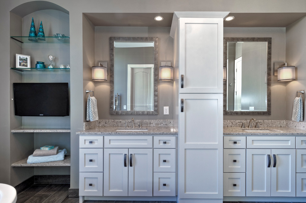 This is an example of a transitional master bathroom in Columbus with an undermount sink, white cabinets, engineered quartz benchtops, a freestanding tub, an alcove shower, a one-piece toilet, gray tile, wood-look tile, grey walls and ceramic floors.