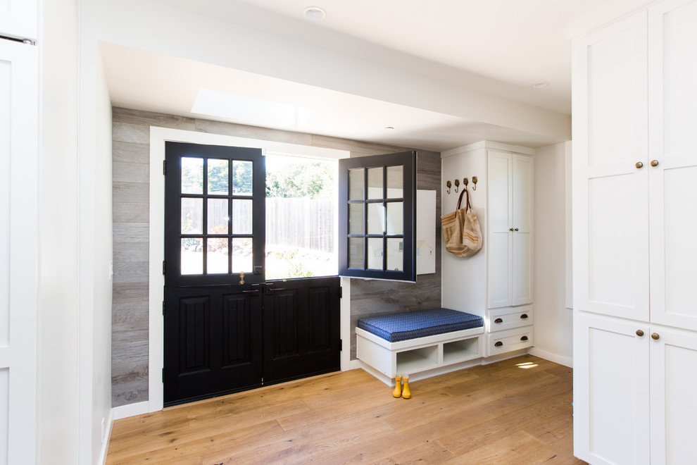 Design ideas for a transitional mudroom in Sacramento with white walls, medium hardwood floors, a dutch front door, a black front door and brown floor.