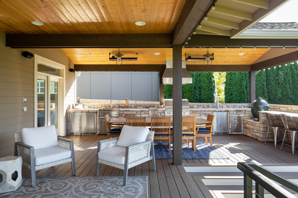 Design ideas for a large contemporary backyard and ground level deck in Seattle with an outdoor kitchen, a roof extension and metal railing.
