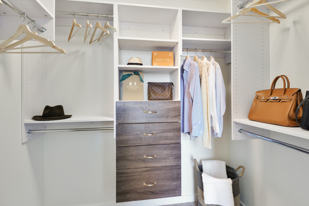 This is an example of a small contemporary gender-neutral walk-in wardrobe in Atlanta with dark wood cabinets.