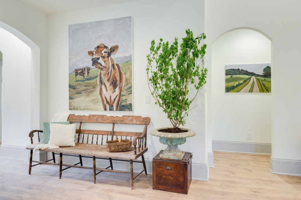 Example of a mid-sized transitional medium tone wood floor and brown floor foyer design in Orange County with white walls and a white front door
