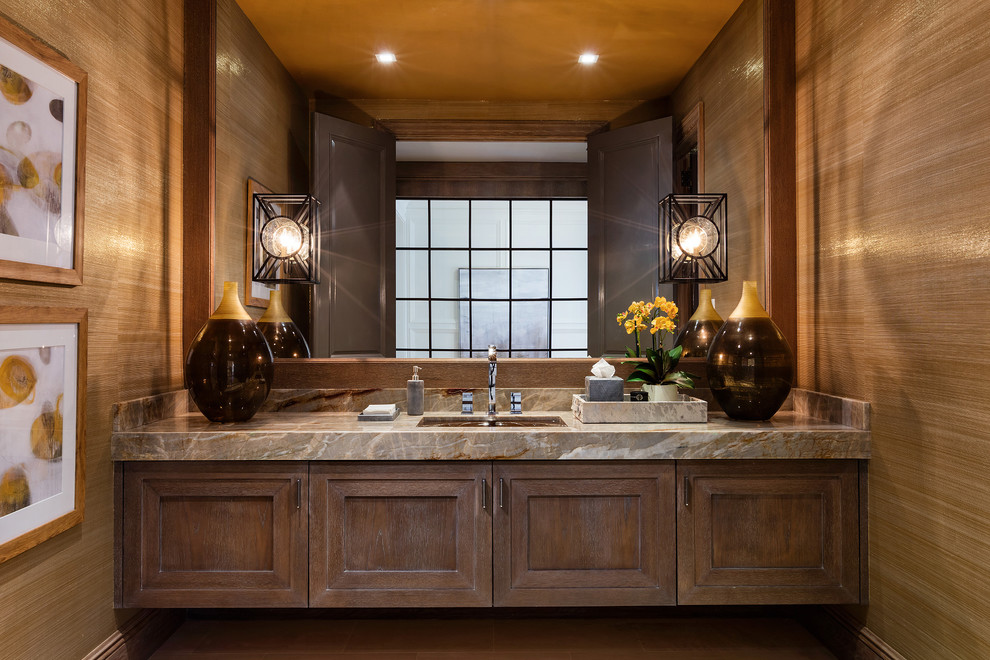 Transitional powder room in Other with recessed-panel cabinets, brown cabinets, marble benchtops, brown walls, an undermount sink and grey benchtops.