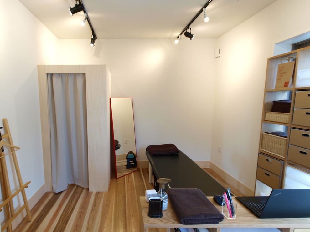 This is an example of a scandinavian home weight room in Tokyo with white walls, light hardwood floors and beige floor.