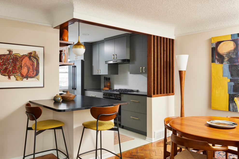 Example of a small 1950s galley linoleum floor and beige floor kitchen design in Minneapolis with an undermount sink, flat-panel cabinets, gray cabinets, quartz countertops, white backsplash, ceramic backsplash and black countertops