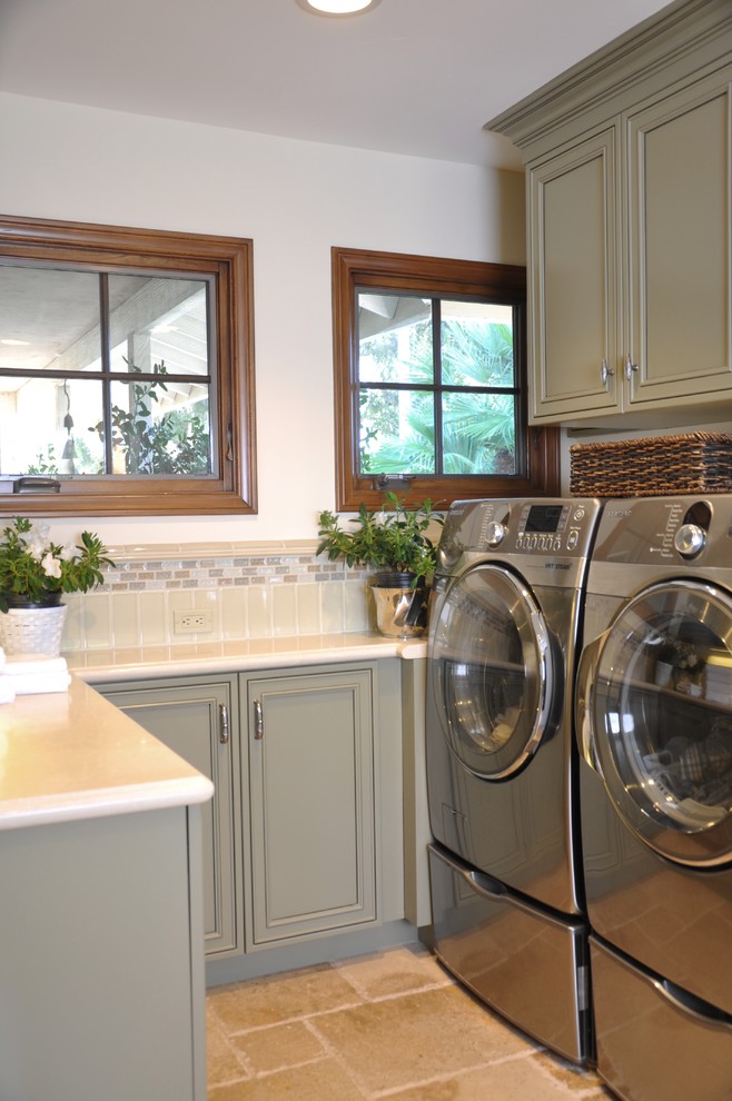 Design ideas for a mid-sized traditional u-shaped laundry room in San Diego with an undermount sink, recessed-panel cabinets, grey cabinets, limestone benchtops, white walls, travertine floors, a side-by-side washer and dryer and red floor.