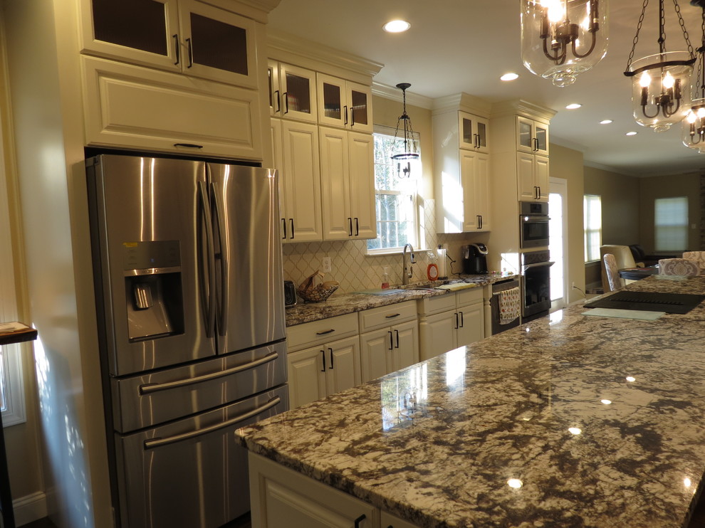 Inspiration for a large transitional galley dark wood floor and brown floor kitchen remodel with a double-bowl sink, raised-panel cabinets, white cabinets, granite countertops, white backsplash, porcelain backsplash, stainless steel appliances and an island