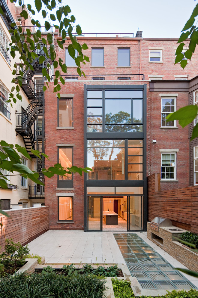 Photo of a contemporary three-storey brick townhouse exterior in New York.