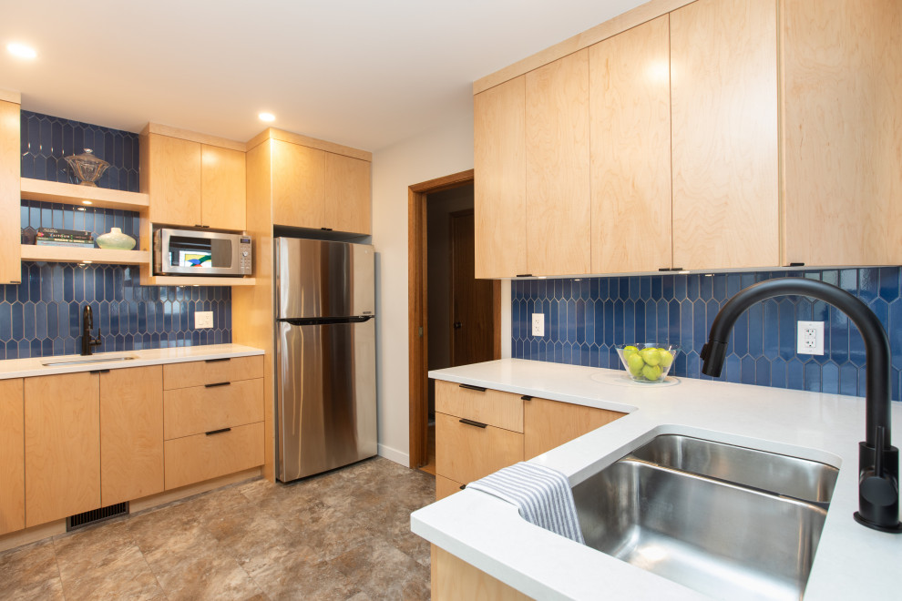 Photo of a mid-sized modern l-shaped separate kitchen in Other with an undermount sink, flat-panel cabinets, light wood cabinets, quartz benchtops, blue splashback, ceramic splashback, stainless steel appliances, vinyl floors, no island, beige floor and white benchtop.