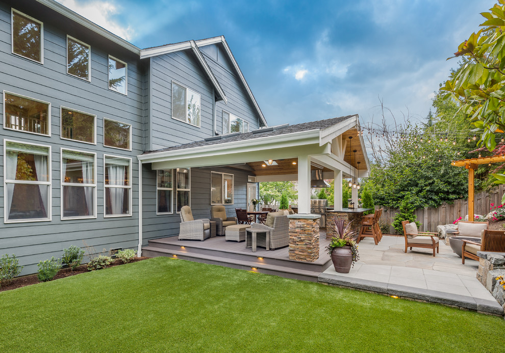 Photo of a large arts and crafts backyard patio in Seattle with an outdoor kitchen, a roof extension and decking.