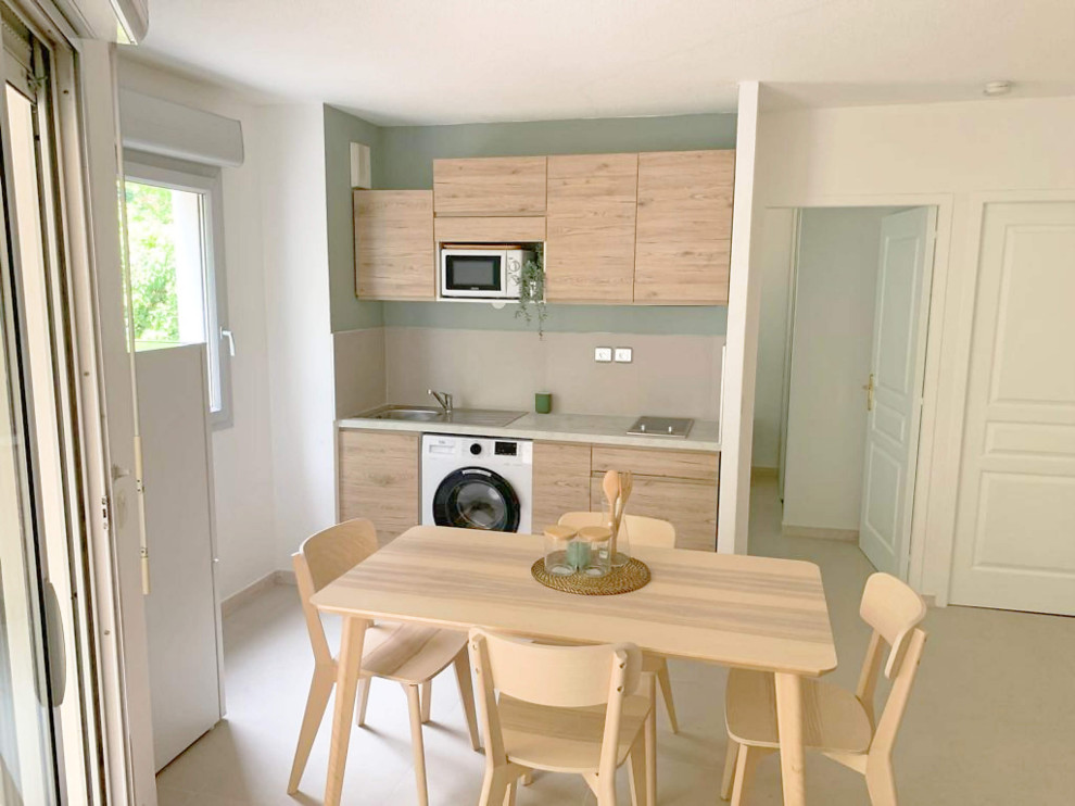 Photo of a small scandinavian single-wall open plan kitchen in Montpellier with ceramic floors, beige floor, a single-bowl sink, light wood cabinets, beige splashback, white appliances, no island and beige benchtop.
